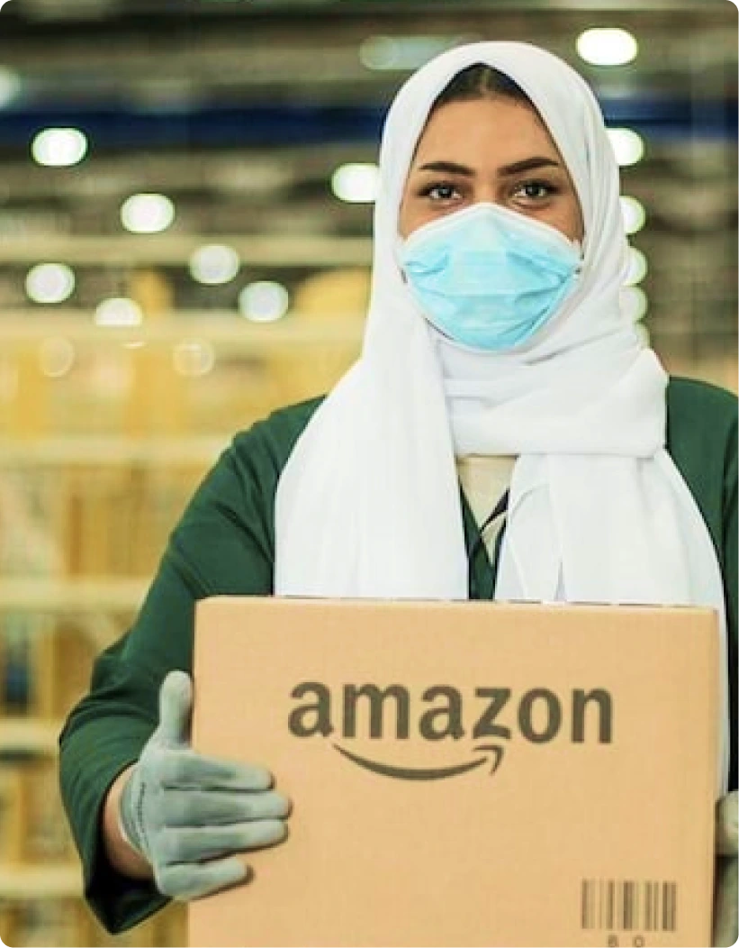 Amazon employee in UAE holding a package at a fulfillment center, representing Amazon's trusted use of the .ae domain for business in the United Arab Emirates.