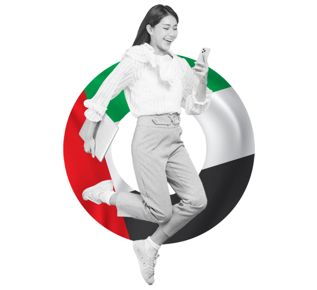 A happy businesswoman jumps for joy while looking at her phone, with a UAE flag in the background, symbolizing career success with Gatehills.